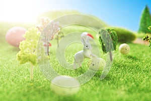 Rabbit and easter eggs in green grass with blue sky.