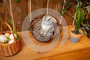 rabbit figurine in a wicker basket in the decorations for the Easter holiday