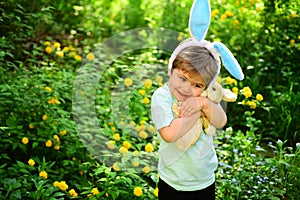 Rabbit kid with bunny ears. Hare toy. Egg hunt on spring holiday. love easter. Family holiday. Little boy child in green