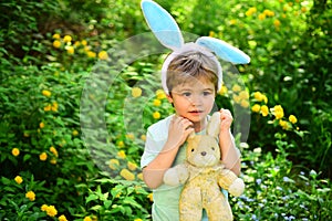 Rabbit kid with bunny ears. Hare toy. Egg hunt on spring holiday. love easter. Family holiday. Little boy child in green