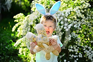 Rabbit kid with bunny ears. Hare toy. Little boy child in green forest. Egg hunt on spring holiday. love easter. Family