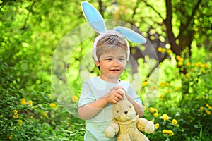 Rabbit kid with bunny ears. Hare toy. Little boy child in green forest. Egg hunt on spring holiday. love easter. Family