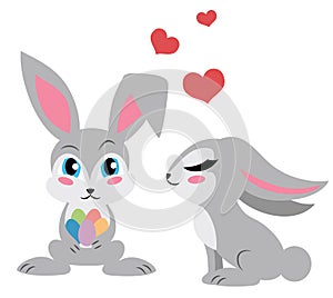 Two cute rabbits. One holding eggs. Isolated obn white.