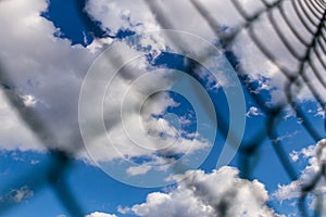 Rabitz metal mesh fence against blue sky background.