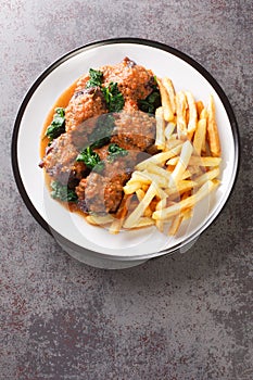 Rabo De Toro delicious dish in Spain is oxtail stew served with french fry closeup in the plate. Vertical top view