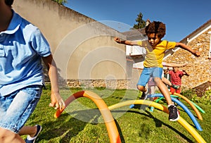 Race with obstacles many kids jump over barrier