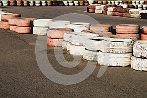 Race track safety barrier. asphalt racing track with red and white tires. colorful tires stack. karting racetrack