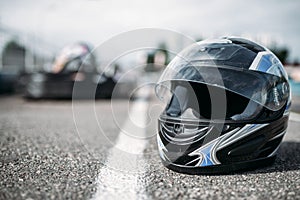 Racer helmet on asphalt, karting sport concept photo