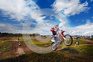 Racer jumps on trampoline motorcycles dirtbike blue sky