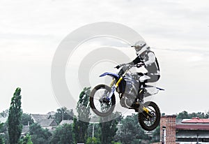 The racer on a motorcycle participates in a motocross race, jumps on a springboard.