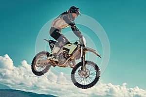 Racer on mountain bike participates in motocross race, takes off and jumps on springboard, against the blue sky. Close