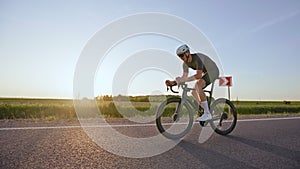 Racer performing exercise ride on road bike on field scenery