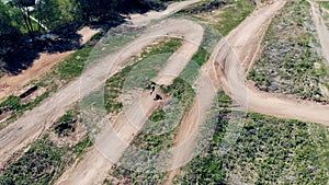 A racer is riding a motorbike through the hilly track