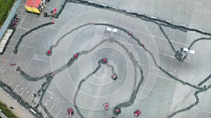 Racers traning or competing on the karting track in protective uniform and helmet, aerial view. Media. Kart driving