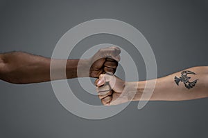 Racial tolerance. Respect social unity. African and caucasian hands gesturing isolated on gray studio background