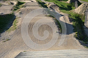 Racing atrium bmx track for imported riders with undulating terrain tilted track with turns and jumps. wooden bridges and ramps ar