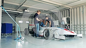 Racing car is getting checked by garage specialists
