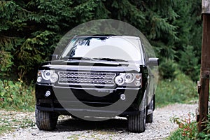 racing concept. SUV covered with mud. Crossover overcomes obstacles on autumn day in forest. Off-road car on bad gravel road.