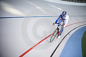 Racing cyclist on velodrome outdoor.