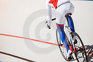 Racing cyclist on velodrome outdoor.