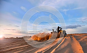 Racing powerful quad bike on the difficult sand in the summer