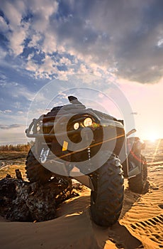 Racing powerful quad bike on the difficult sand in the summer