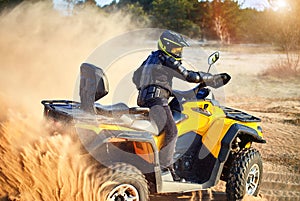 Racing powerful quad bike on the difficult sand in the summer