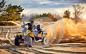 Racing powerful quad bike on the difficult sand in the summer