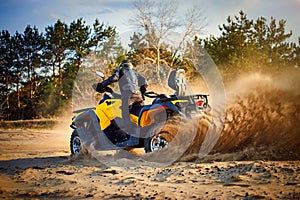 Racing powerful quad bike on the difficult sand in the summer