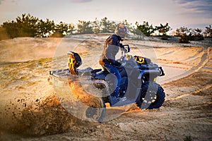 Racing powerful quad bike on the difficult sand in the summer