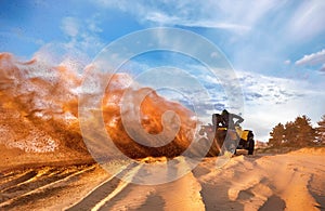 Racing powerful quad bike on the difficult sand in the summer