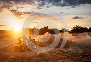 Racing powerful quad bike on the difficult sand in the summer