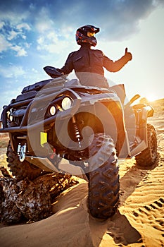 Racing powerful quad bike on the difficult sand in the summer