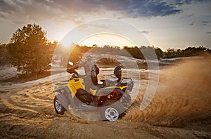 Racing powerful quad bike on the difficult sand in the summer