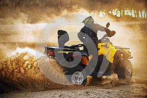 Racing powerful quad bike on the difficult sand in the summer