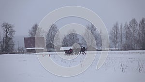 Racing in winter at a trot on the racetrack on a cold winter day.