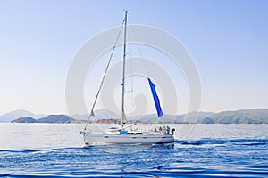 Racing yacht in the sea on blue sky background. Peaceful seascape. Beautiful blue sky over calm sea