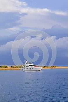 Racing yacht in the sea on blue sky background. Peaceful seascape. Beautiful blue sky over calm sea