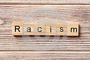 Racism word written on wood block. Racism text on table, concept