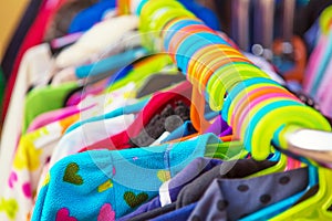 Rack of baby and children jackets and clothes displayed at outdoor hanger market for sale.