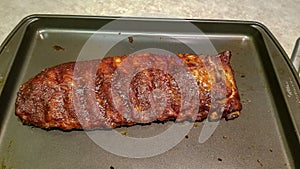 Rack of barbequed pork ribs ready to serve, uncut