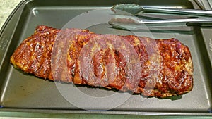 Rack of barbequed pork ribs ready to serve, uncut