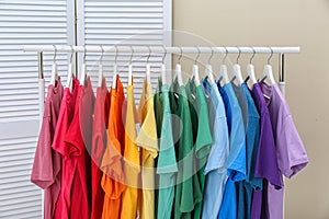 Rack with bright clothes in room