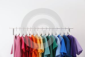 Rack with bright clothes on white background.