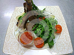Rack of calf and lettuce and tomatoes photo