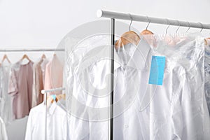 Rack with clean clothes on hangers