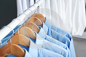 Rack with clean clothes on hangers after dry-cleaning