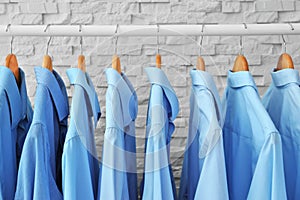 Rack with clean clothes on hangers after dry-cleaning