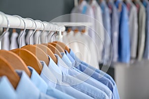 Rack with clean clothes on hangers after dry-cleaning