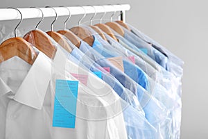 Rack with clean clothes on hangers after dry-cleaning